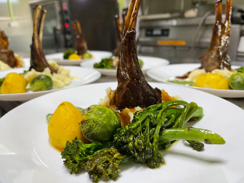 Plated dinner of lamb cutlets with seasonal vegetables at Club Boutique Hotel restaurant